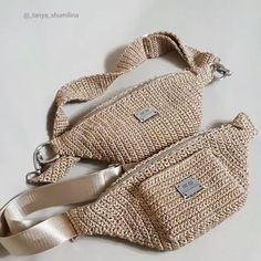 two purses sitting on top of a white table