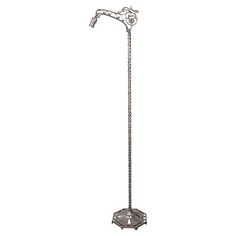 a metal floor lamp with an ornate design on the top and bottom, standing in front of a white background