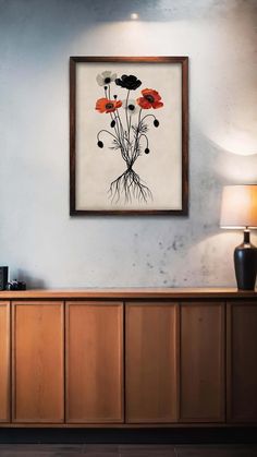 an art piece hanging on the wall above a wooden cabinet with flowers painted on it