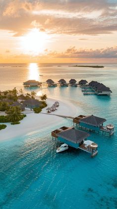 an aerial view of the ocean with boats and houses in the water at sunset or sunrise