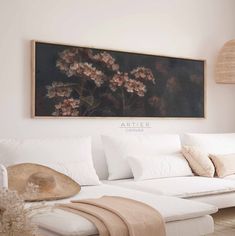 a living room with a white couch and large painting on the wall above it that says arteier canvass