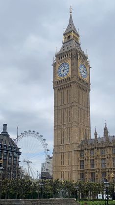 the big ben clock tower towering over the city of london with ferris wheel in the background