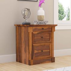 a wooden cabinet with two drawers and a clock on it's side table next to a window