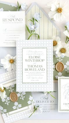 the wedding stationery is laid out on top of each other, with white flowers