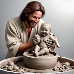 a man holding a baby in front of a clay sculpture