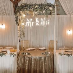 a table set up for a wedding with gold sequins and greenery on it