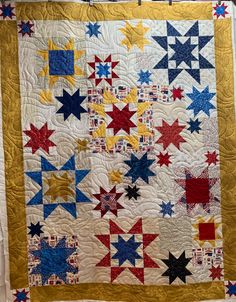 a quilted wall hanging with red, white and blue stars