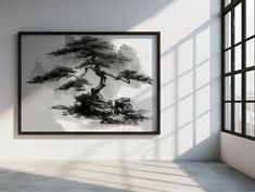 a black and white painting hanging on the wall next to an open window in a room