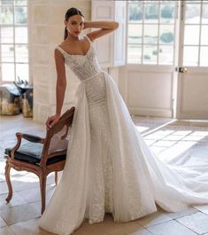 a woman in a wedding dress leaning on a chair