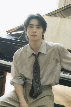 a young man sitting in front of a piano