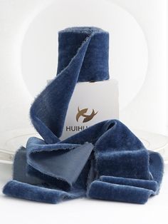 a pile of blue towels sitting on top of a white plate next to a napkin