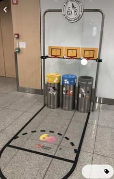 the entrance to an airport with trash cans on the floor