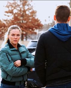 a woman standing next to a man on the street