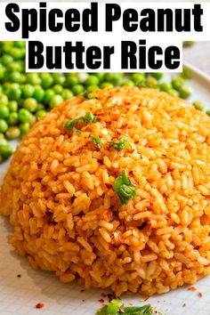 a white plate topped with rice and peas next to green beans on a table top