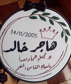 a close up of a cake on a table with writing in arabic and an image of a crown