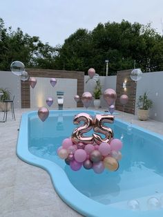 a pool with balloons floating in it and the number twenty