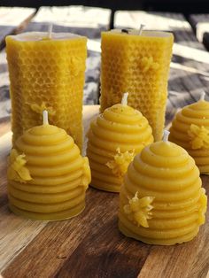 beeswax candles are sitting on a cutting board next to some honeycombs