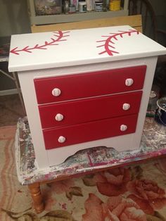 a red and white dresser sitting on top of a rug