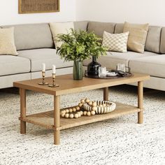 a living room with a couch, coffee table and vase on the floor in front of it