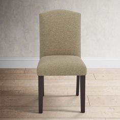 a brown chair sitting on top of a hard wood floor next to a white wall