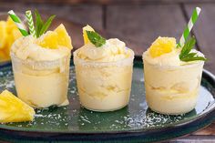 three desserts on a plate with pineapple and mint garnish