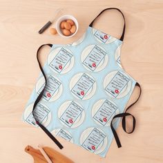 an apron that is sitting on top of a table next to some wooden spoons