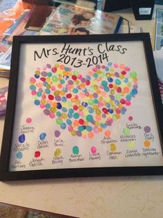 a framed poster with balloons in the shape of a heart on top of a table