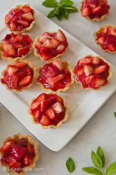 strawberry tarts on a plate with mint leaves