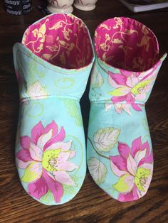 two slippers with flowers on them sitting on a table