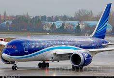 a blue and white airplane is on the runway