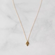 This hasma charm necklace is delicate and minimal, perfect for everyday wear jewelry.  This hand of fatima dainty necklace has a protective vibe and is perfect for your best friend.  THE DETAILS: 🖤 14K Gold-filled Necklace  🖤 14, 15, 16, 18, 20, or 24 inches.  (14= small choker, 15= large choker, 16= collarbone, 18= standard, 20= long, 24 = extra long) 🖤 14k Gold Filled Hamsa charm size 8mm (25mm=1 inch)  🖤 Lead and Nickel Free  ✨ Made to empower the wearer and make her feel special, A Worthy Brand crafts good karma jewelry for women everywhere. View A Worthy Brand's shop here: https://etsy.me/2kMo3qx READY TO GIFT: Orders come in a branded jewelry box tied with a satin ribbon. There is an option to have your order gift wrapped for an additional $5 with silver wrapping paper at checkou Hamsa Hand Necklace, Karma Jewelry, Silver Wrapping Paper, Hamsa Jewelry, Everyday Wear Jewelry, Make Her Feel Special, Hamsa Charm, Gold Hamsa, Hamsa Necklace