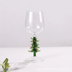 a wine glass with a small christmas tree on it