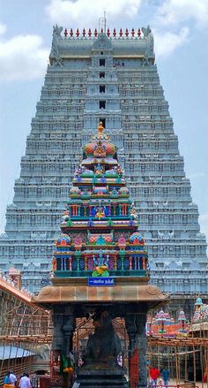 a very tall and colorful structure with people around it