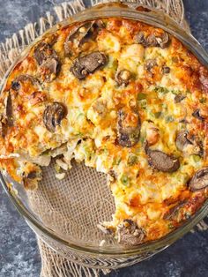 a casserole with mushrooms and cheese in a glass dish on top of a table