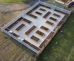 an aerial view of a yard with raised beds in the middle and grass on the other side