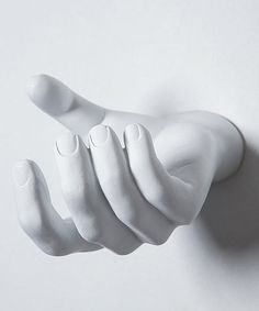 a white ceramic hand is hanging on the wall