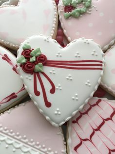 heart shaped cookies with red ribbon and bows on them are arranged in a pile for valentine's day