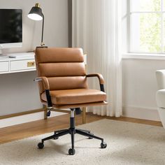 a brown leather office chair sitting in front of a desk with a computer on it