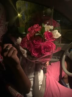 a bouquet of pink roses is sitting in the passenger's seat of a car