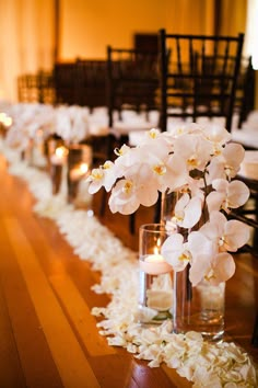 flowers and candles are lined up along the aisle