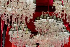 a chandelier hanging from the ceiling in a room with red walls and curtains