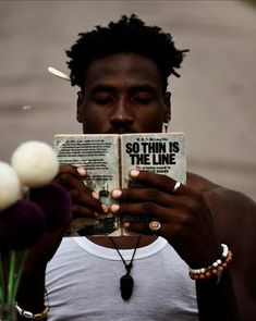 a man reading a book with flowers in front of him and the caption so thin is the line