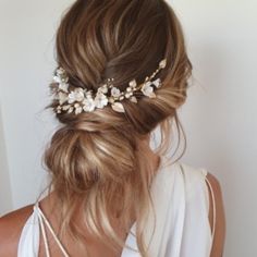 a woman with blonde hair wearing a white top and flowered headpiece in her hair