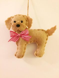 a brown dog ornament with a red bow on it's neck hanging from a cord