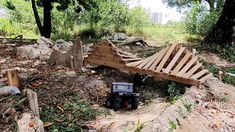 a truck is parked on the side of a dirt road next to a pile of wood