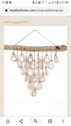 an image of a wind chime hanging from a wooden branch with white discs on it