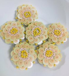 six decorated cupcakes sitting on top of a white plate with yellow and pink frosting