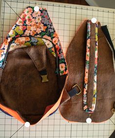 two purses sitting on top of a cutting board