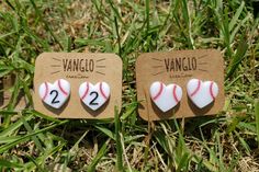 two pins with baseballs on them are sitting in the grass, one is for each other