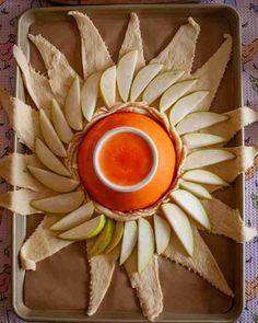 an arrangement of fruit and chips arranged in the shape of a sunflower on a tray